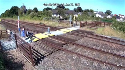 Child steps out onto level crossing in front of oncoming train