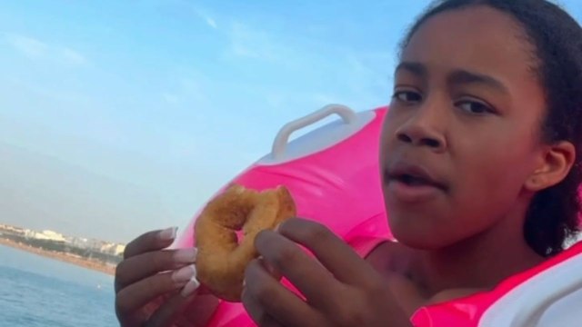 Beach day twist: Seagull swoops in and snatches doughnut from the girl's hand