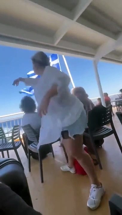 Elle balance l'enceinte de touriste par dessus bord sur un bateau de croisiere