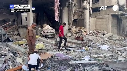 فلسطينيون يعاينون الدمار إثر غارة إسرائيلية في البريج