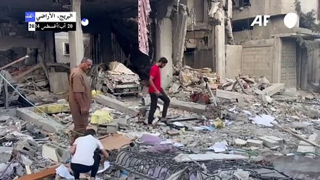 فلسطينيون يعاينون الدمار إثر غارة إسرائيلية في البريج