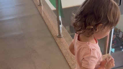 Little girl pretends to head out for a party in mom’s heels and lipstick