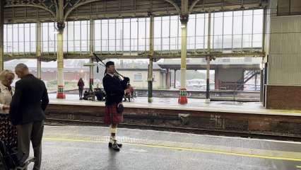 Man playing bagpipes at Preston railway station
