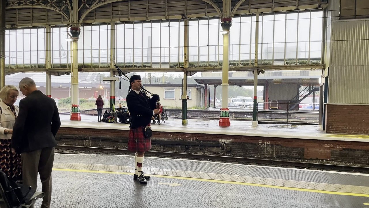 Man playing bagpipes at Preston railway station