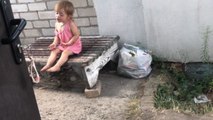 Tiny tot imagines herself performing for a huge audience in the backyard