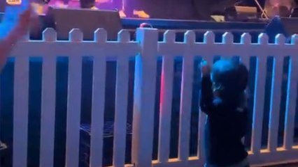 Little girl enthusiastically copies dad's dance moves during his live show performance