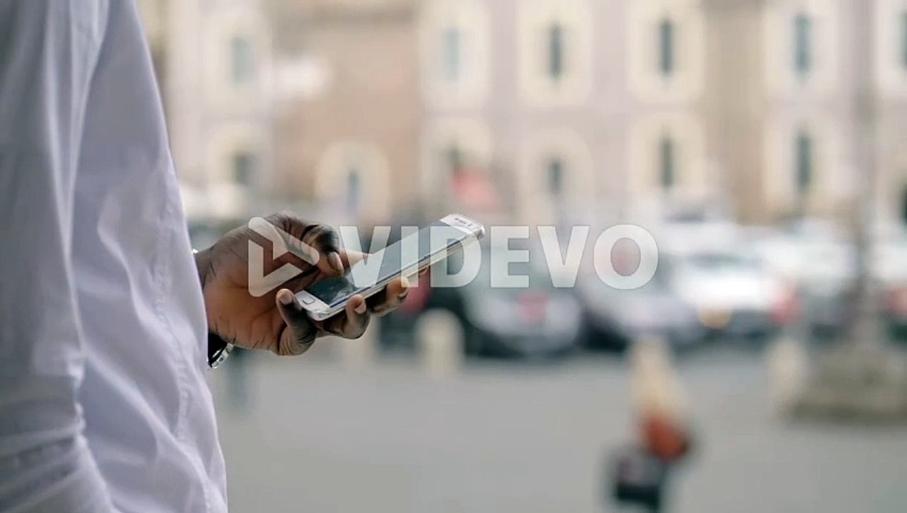 young african Man’s Hands Holding Modern Smartphone