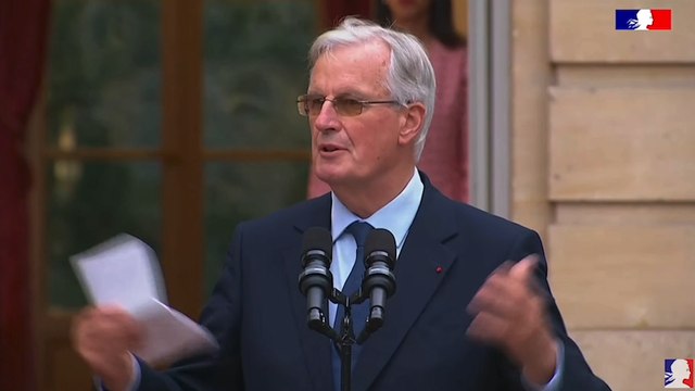 Michel Barnier salue les gens d'en bas lors de la passation de pouvoir à Matignon