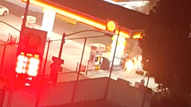 Aftermath of fiery explosion at gas station caused by severe car crash