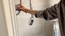 Woman comically struggles with an out-of-control high-pressure shower head