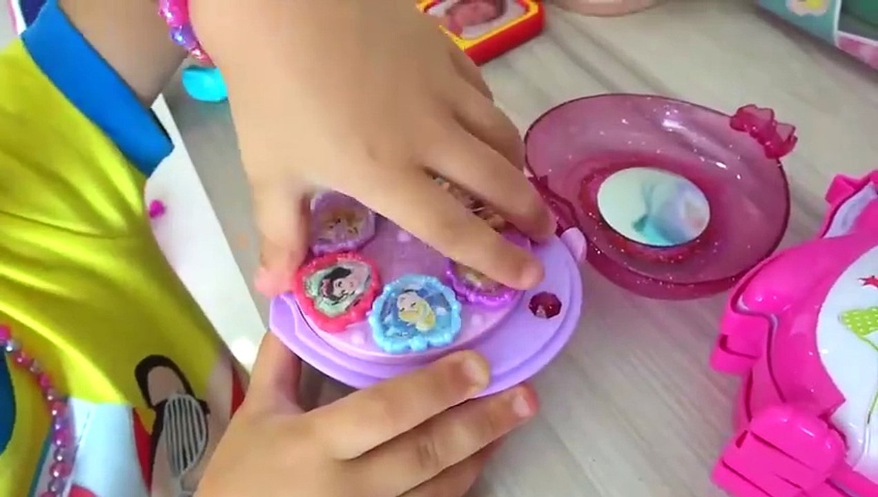Diana e Roma brincam com uma mesa de maquiagem de brinquedo