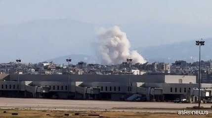 A Beirut l'aereo atterra mentre si alza il fumo del raid israeliano
