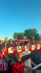 Atleti fans jumping and singing as the team bus drives through