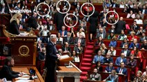 Des députés LFI brandissent leur carte électorale pendant le discours de Barnier à l'Assemblée