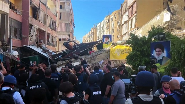 مؤيدو حزب الله يرفعون صور حسن نصر الله بين أنقاض المباني المدمرة في ضاحية بيروت