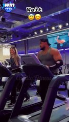 A boy is working out in the gym in front of girls.