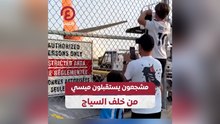 مشجعون يستقبلون ميسي من خلف السياج