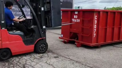 Comical forklift fail as operator struggles to dump scrap metal, resulting in a big mess