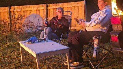 Woman lost in her phone lets out a scream after campfire prank surprises her
