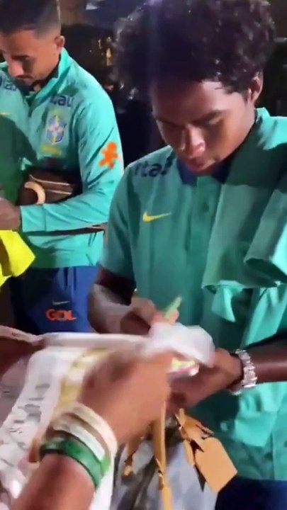 Endrick playig "clash royale" while signing shirts