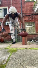 Guy doing pushups with two footballs and a hammer balancing on top of bricks!