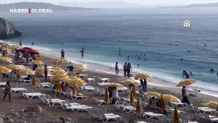 Antalya'nın turistlerini yağmur durdurmadı: Dünyaca ünlü plaja akın