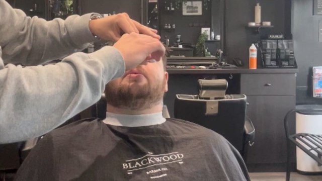 Tense moment: Barber struggles to remove nose wax strip stuck in client's nose