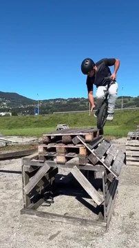 Man on Unicycle Makes Jump Onto Pile of Wooden Pallets