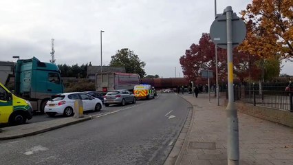 Emergency vehicles with flashing blue lights on held up by freight train in Boston