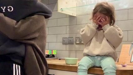 Freches Kind auf Kamera gefangen, vorgibt zu weinen, um eine Umarmung von Dad zu nehmen