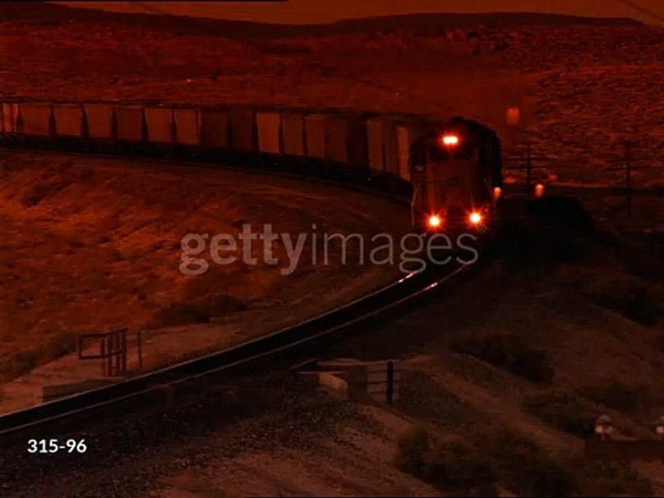gettyimages-315-96-640_adppHigh angle PAN freight train rounding curve towards camera in desert at sunset / filter - stock video