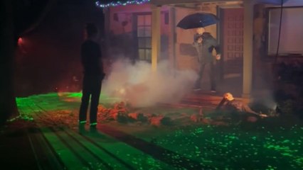 Beetle Claus pours blood on Umbrella Man in a gruesome Halloween yard display