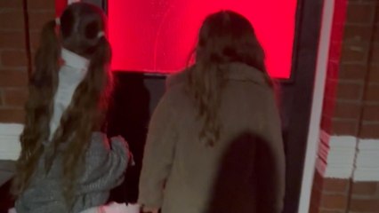 Little girls look inside a spooky house and get startled by a scream