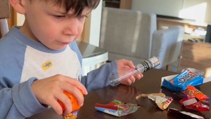Little boy cleans up after parents pretend to eat his Halloween candy stash