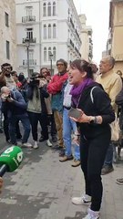 Una dona protesta a l'exterior de les Corts, abans de la compareixença de Mazón