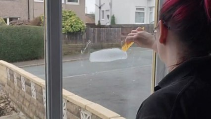 Woman transforms window into a Christmas wonderland with snow art