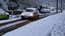 Traffic, walkers and joggers moving slowly in the snow in High Storrs, Sheffield