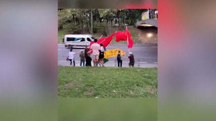 Bayrak taşıyan Çinliler, Brezilyalı protestocuların önünü kapadı