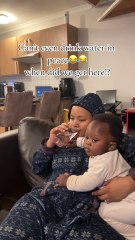 Mom is trying to drink water, but baby insists that she share it!