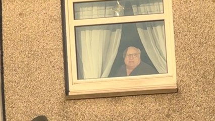 Man finds eerily realistic cutout of an old man peering out from the window