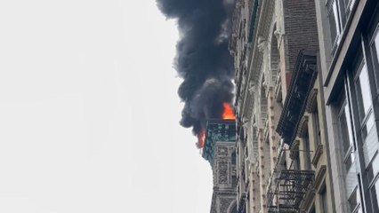 Thick black smoke ascends the sky in SoHo as fire tears through rooftop of prominent building