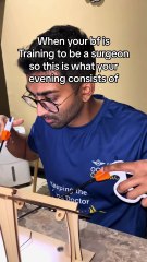 Man is training to be a surgeon and practicing on a laparoscopy box!