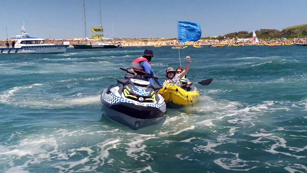 Police officers interact with protesters in a kayak on the water at Newcastle during Rising Tide demonstration | Newcastle Herald | November 23, 2024