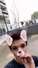 Skateboarder boardslides handrail then falls and land on rear while friend records using dog filter