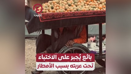 بائع يُجبر على الاختباء تحت عربته بسبب الأمطار