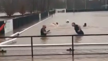 Football team swims in waist-height floodwater on their pitch