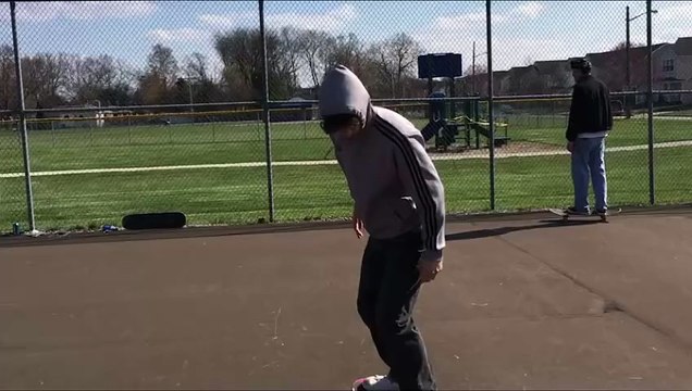 Skateboarder ollies over orange cone then lands on his arm