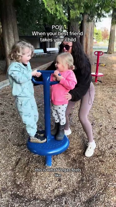 Woman is spinning young children on a playground toy!
