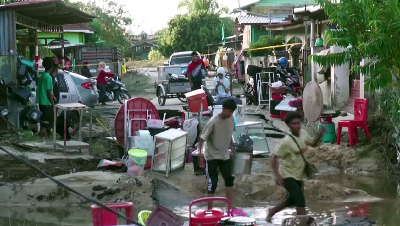 Malaysians survey the damage after devastating floods
