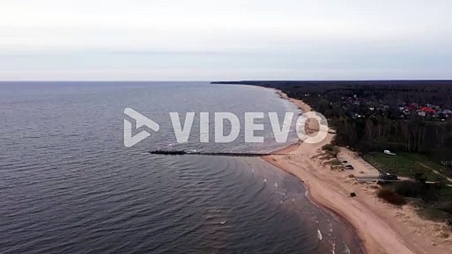 Baltic sea coastline with mole and sandy beach in aerial drone view